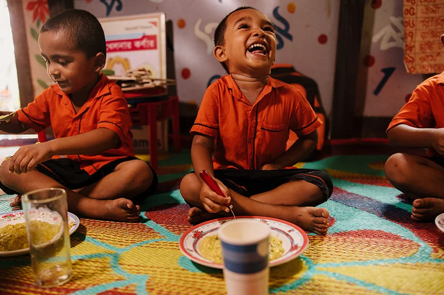 Children enjoy nutritious food prepared by their mothers as part of an early education and nutrition program supported by child sponsorship. (Bangladesh, 2024)