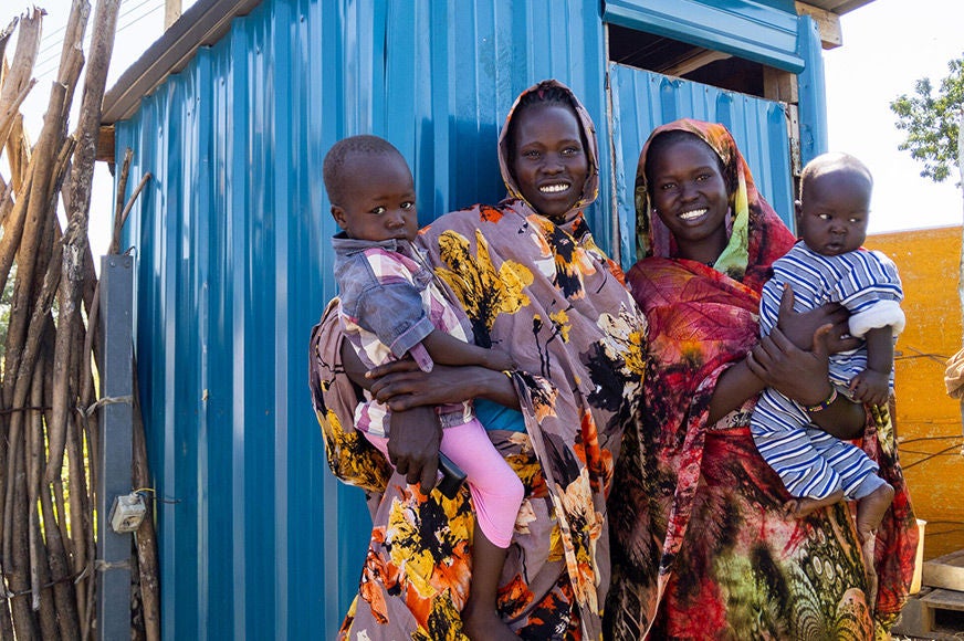 From left: Teresa with her 3-year-old son and Nyankyok with her 5-month-old baby are happy to be provided with latrines for their hygiene and safety. (South Sudan, 2019)