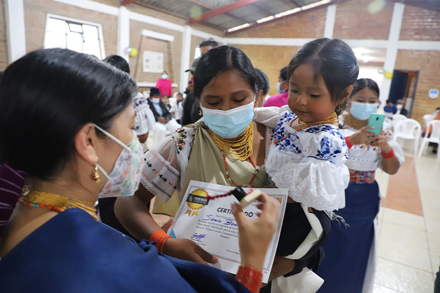 A young woman receives her certificate from World Vision's Youth Ready program, which helps vulnerable youth discover their potential and plan for their future in both work and life. (Ecuador, 2021)