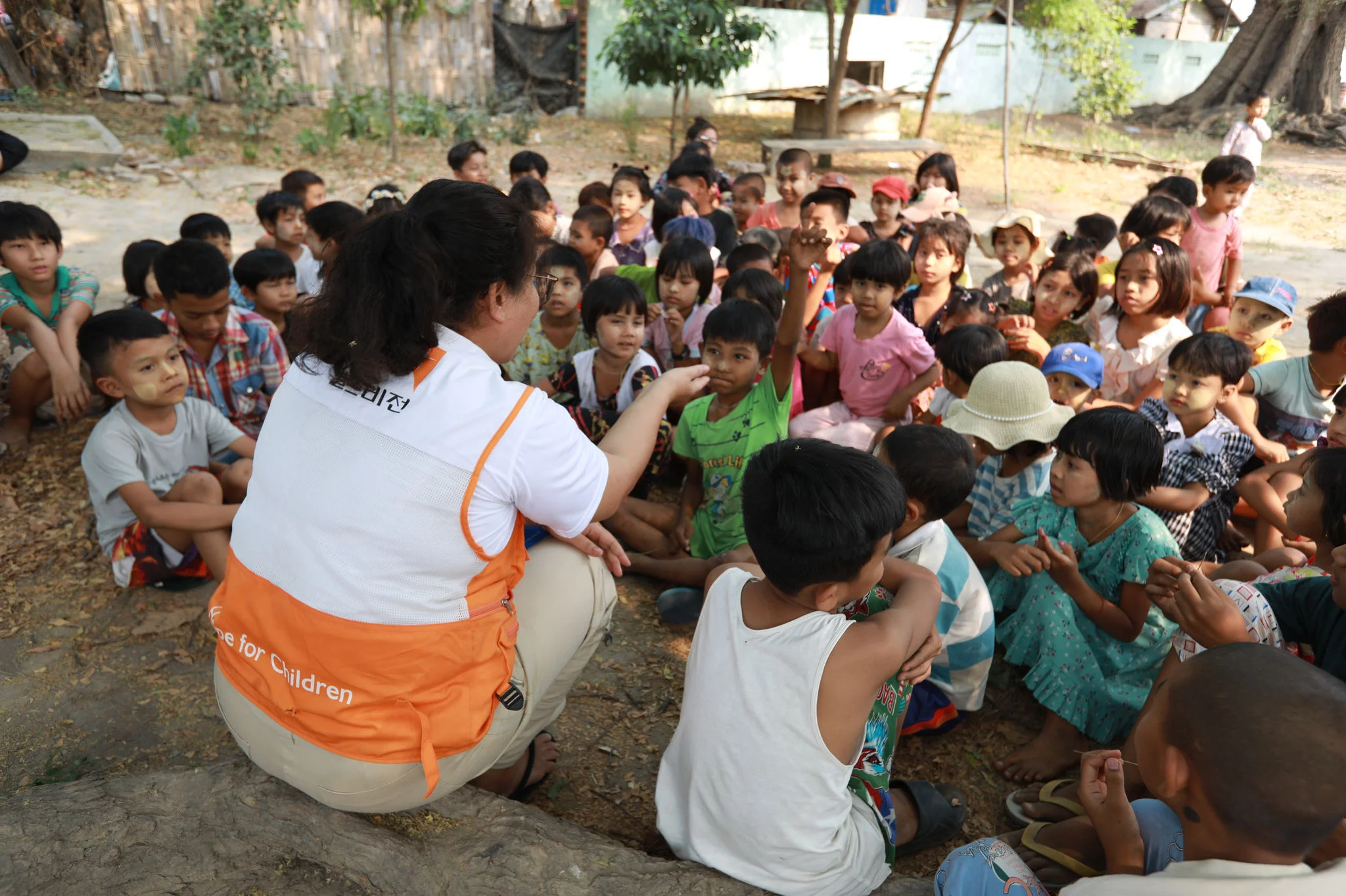 A World Vision volunteer playing and singing with children