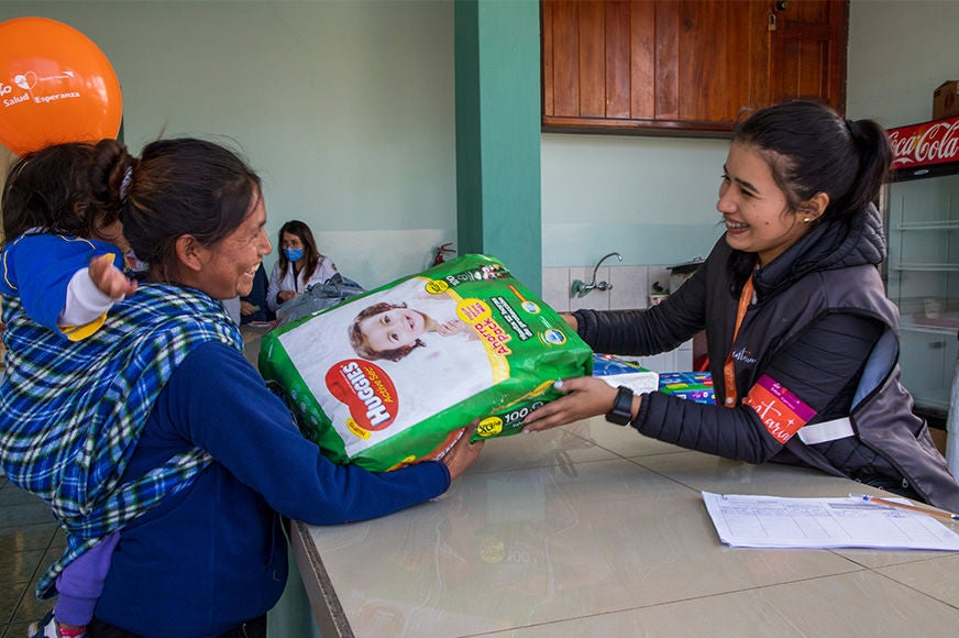 A mother receives an in-kind donation after a health check-up from World Vision’s medical brigade. Ecuador, 2023)