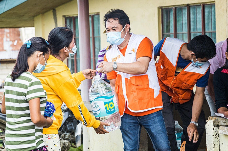 Two women receive emergency supplies from a World Vision staff during a food aid relief in Bohol. (Philippines, 2022)