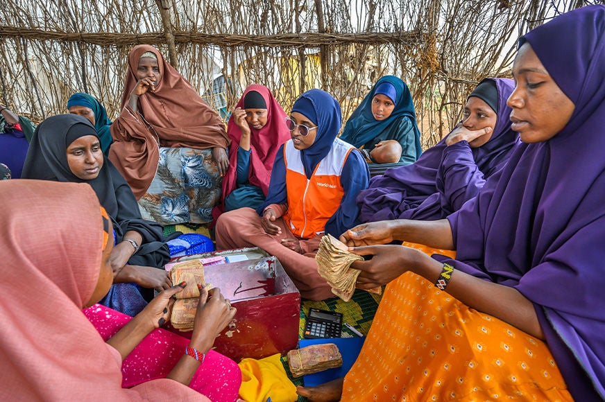 World Vision staff mentors a group of women about savings in an internally displaced persons camp in Baidoa, Somalia. (Somalia, 2023)