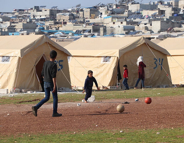 Two boys play soccer in a camp following the earthquake in 2023. (Syria, 2023).