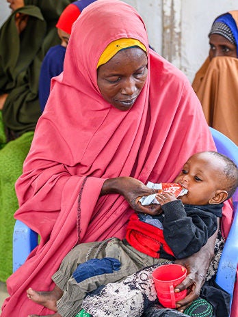 A mother feeds her child Ready-to-Eat Therapeutic nutritional supplement, at the Darusalam Mother and Child Health Center.