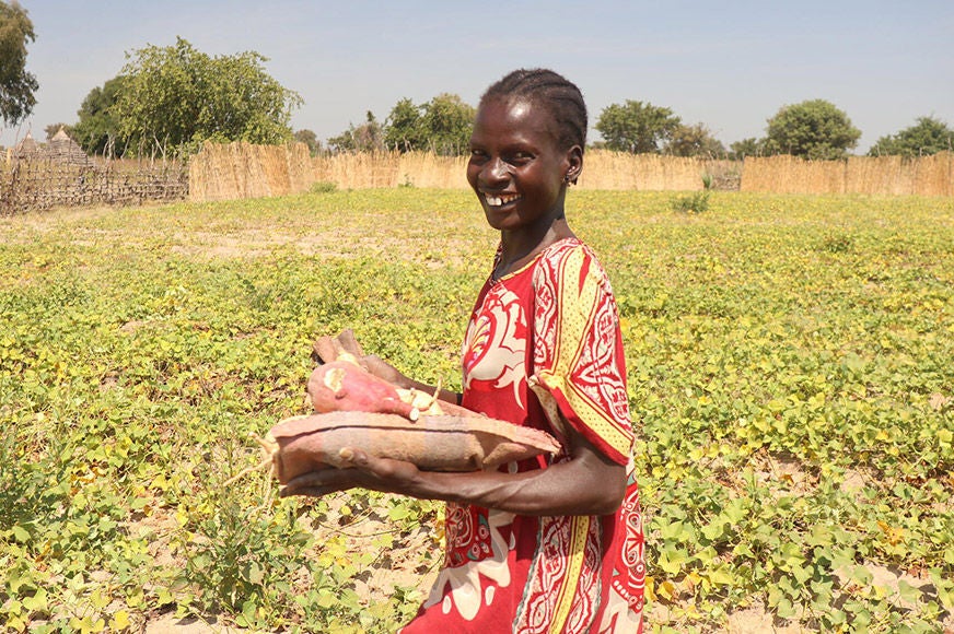 Asunta harvested sweet potatoes she learned how to grow thanks to partnerships with World Vision. (South Sudan, 2022)